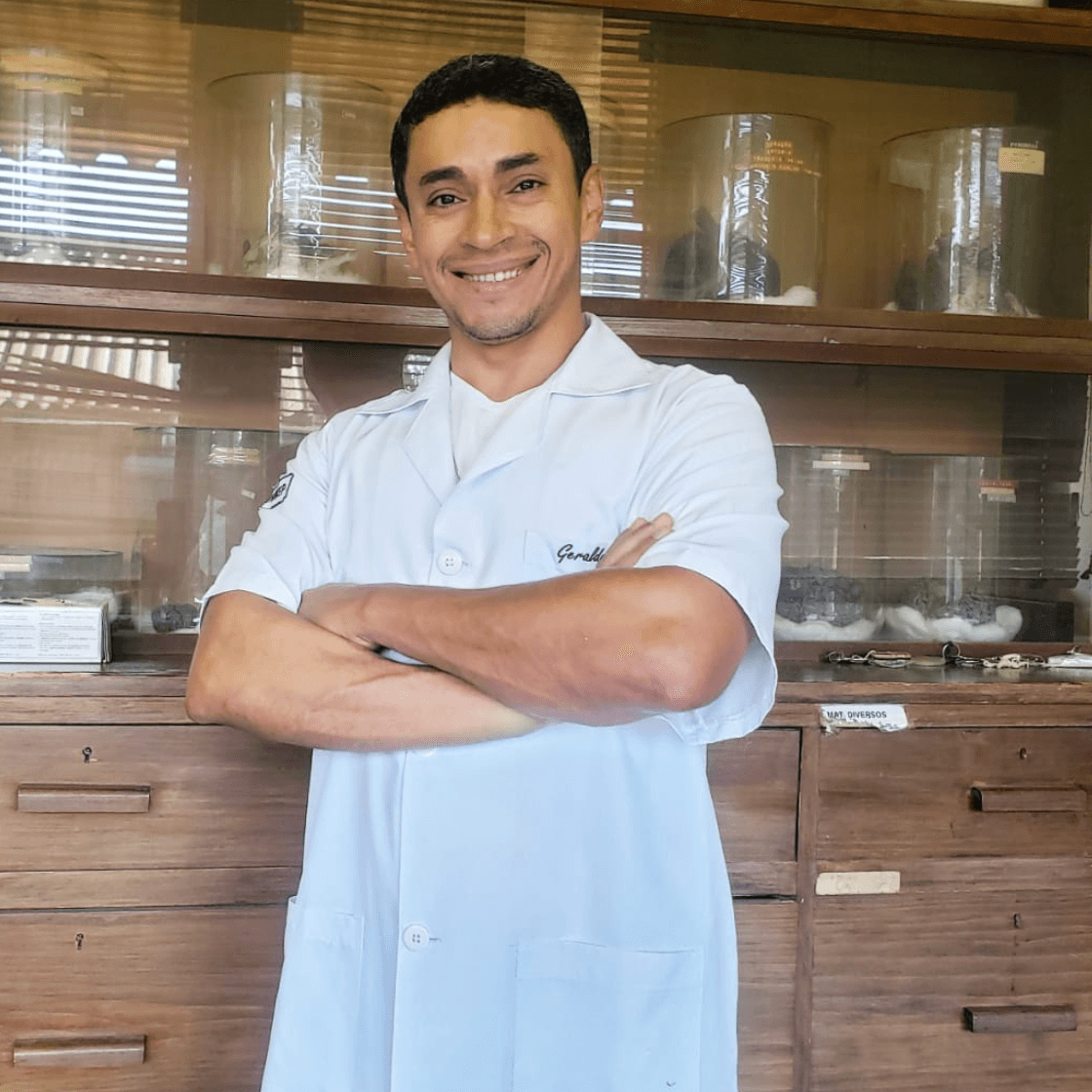 Geraldo Matos em jaleco branco sorrindo em ambiente clínico